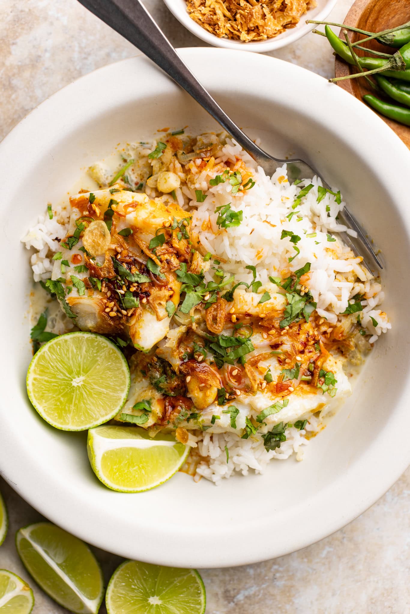 up close bowl of Thai green curry fish made with cod and topped with chili crisp and crispy onions.